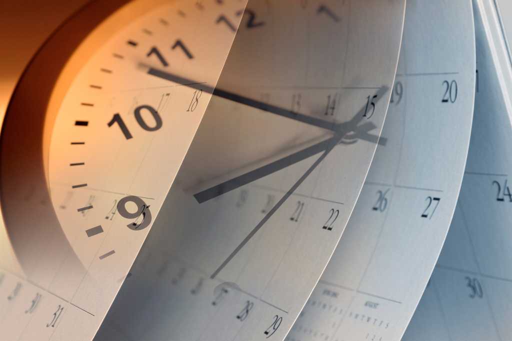 Multiple-exposure shot of a clock and calendar pages. [time / past / future / history / what's next]
